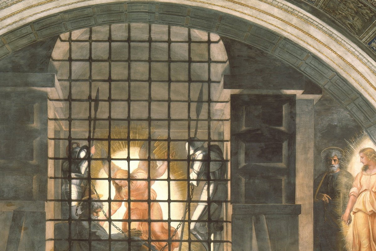 A Renaissance fresco showing a glowing angel waking a chained prisoner between two sleeping guards inside a barred cell.