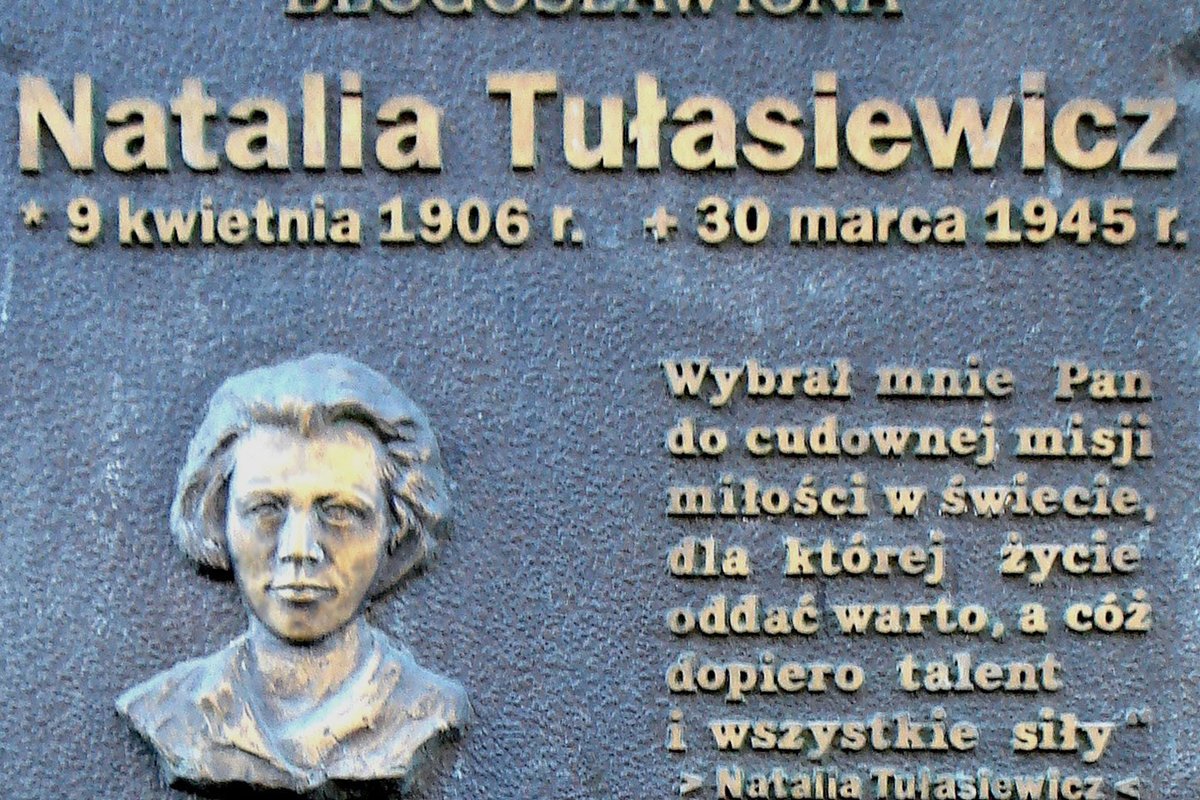 A bronze memorial plaque in Poznań bearing a sculpted relief portrait of Natalia Tułasiewicz's face, her name, dates, and a quotation from her own writing.