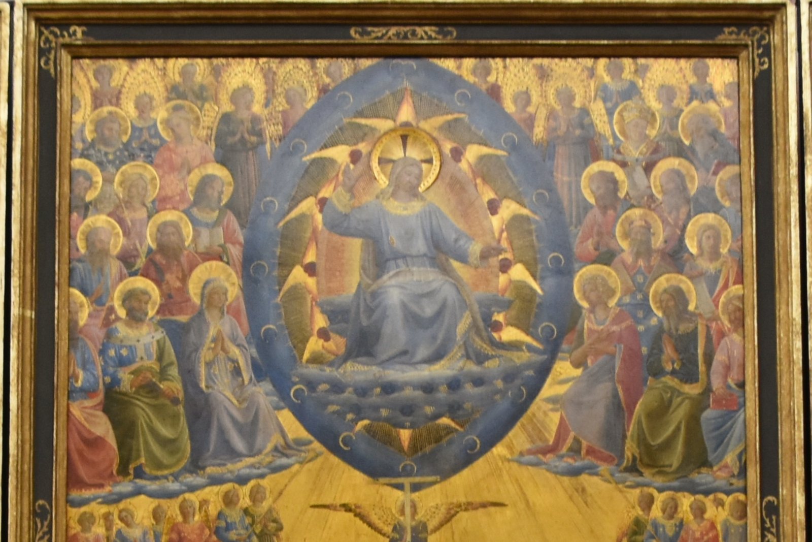 Detail of Fra Angelico's Last Judgment altarpiece showing Christ enthroned in glory surrounded by robed saints and angels in heaven.