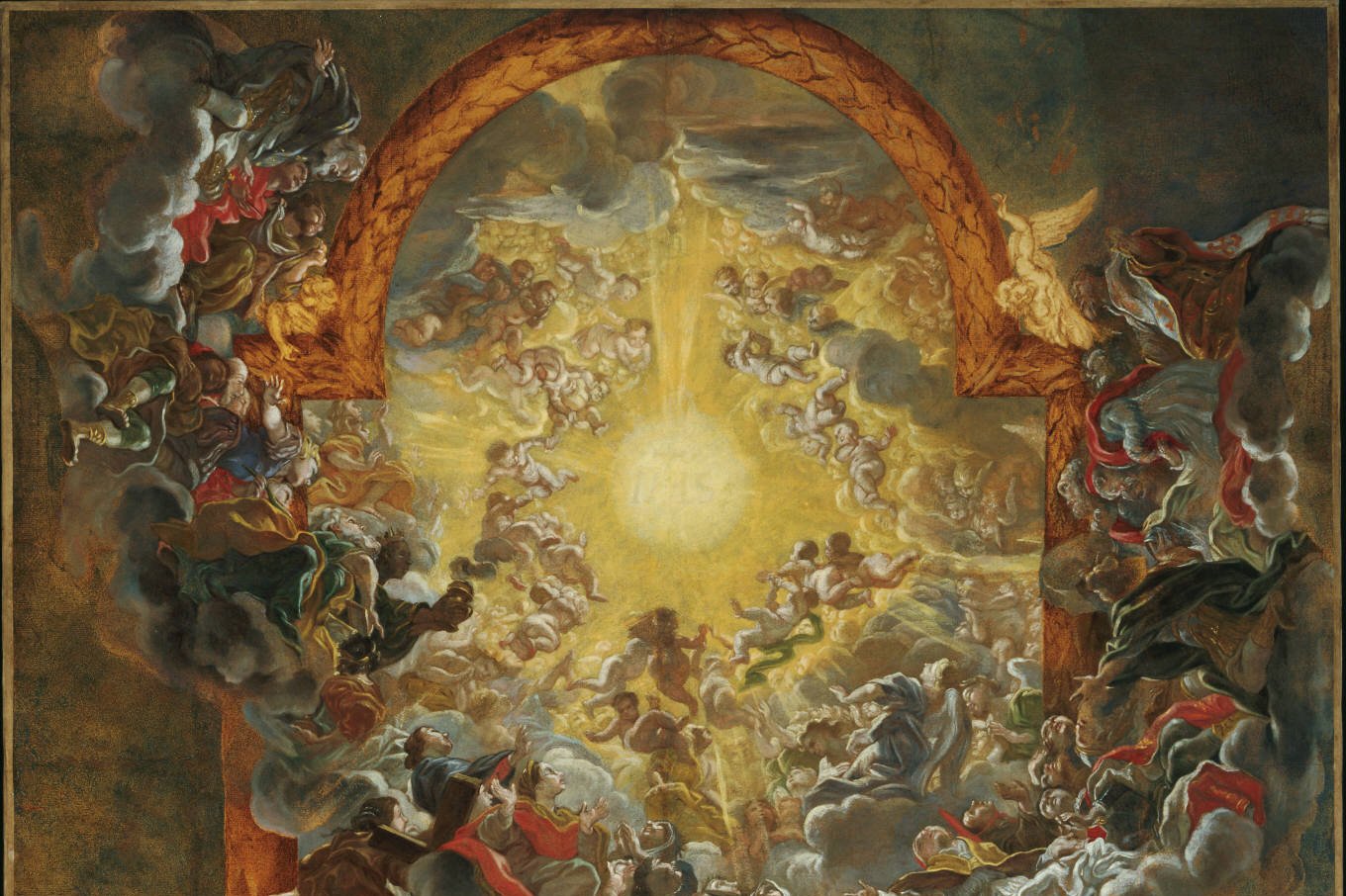 A radiant Baroque ceiling fresco showing the glowing letters IHS surrounded by angels and saints looking upward toward the light.