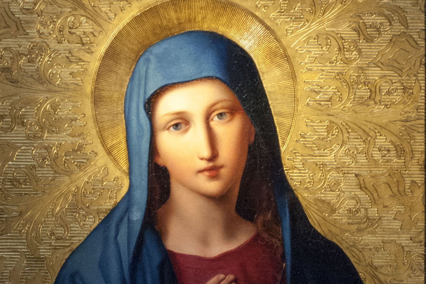 Devotional painting of the Immaculate Heart of Mary, showing Mary in a blue veil with her hand on her heart, pierced by a sword and encircled by roses, against a gold background.