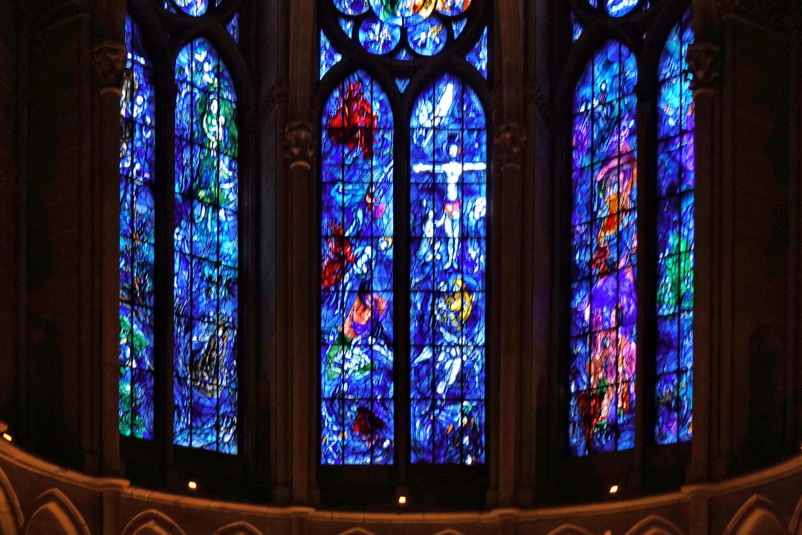 Vivid blue and red stained glass windows designed by Marc Chagall in the ambulatory of Reims Cathedral, France