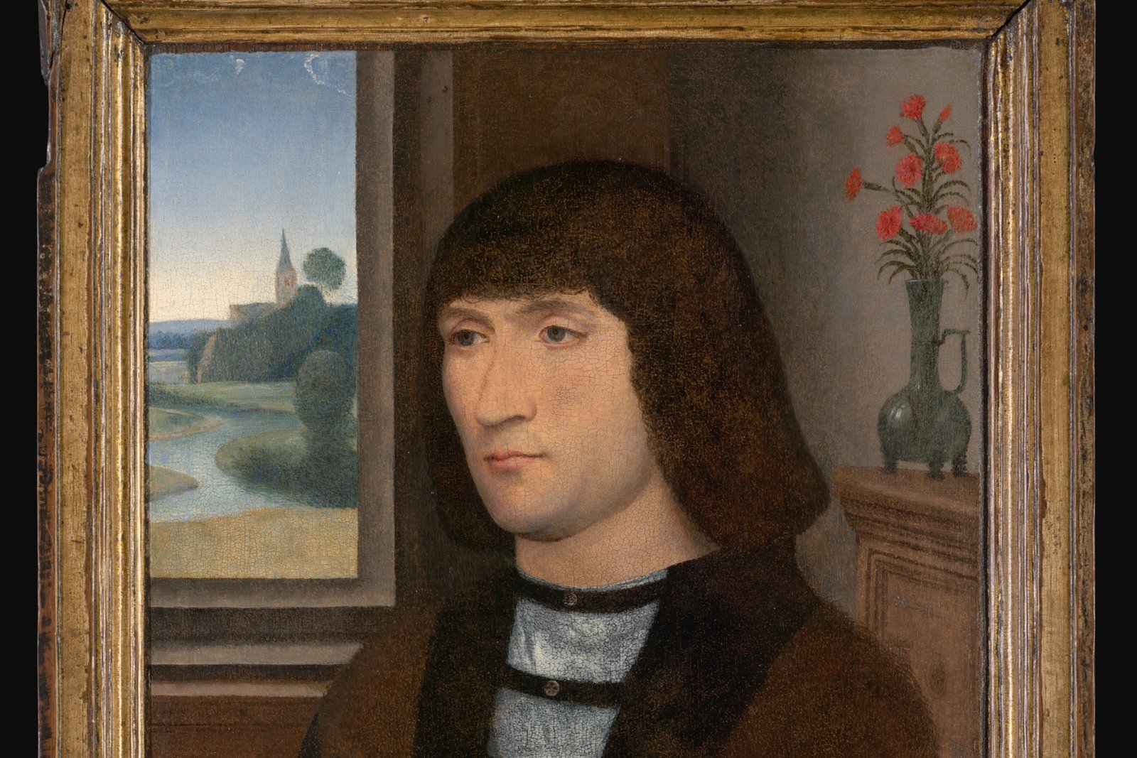 Portrait by Hans Memling of a man in prayer, hands clasped, painted with fine detail against a dark background in the artist's characteristic serene style.