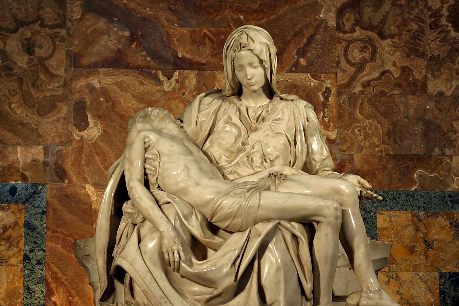 Michelangelo's marble Pietà sculpture showing the Virgin Mary cradling the dead body of Christ across her lap.