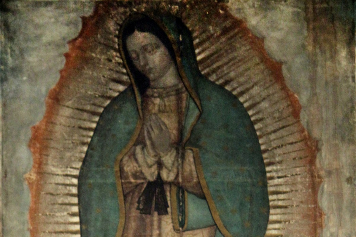Das verblasste Originalbild Unserer Lieben Frau von Guadalupe, das Maria in einem sternenübersäten grünen Mantel zeigt, stehend auf einer Mondsichel, gehalten von einem Engel.