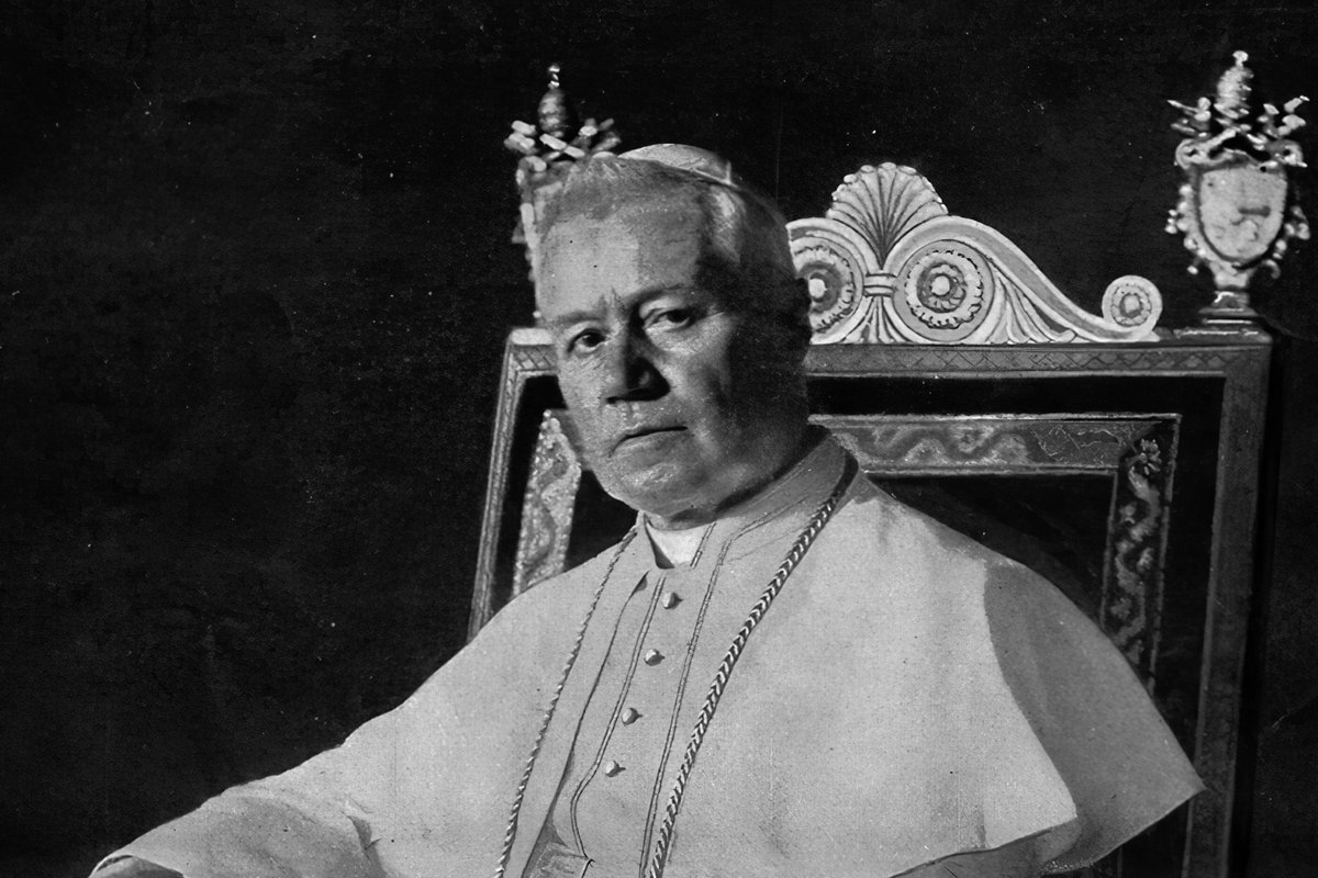 An elderly pope in white papal vestments and a jeweled skullcap sits in an ornate carved throne, one hand resting on the armrest.