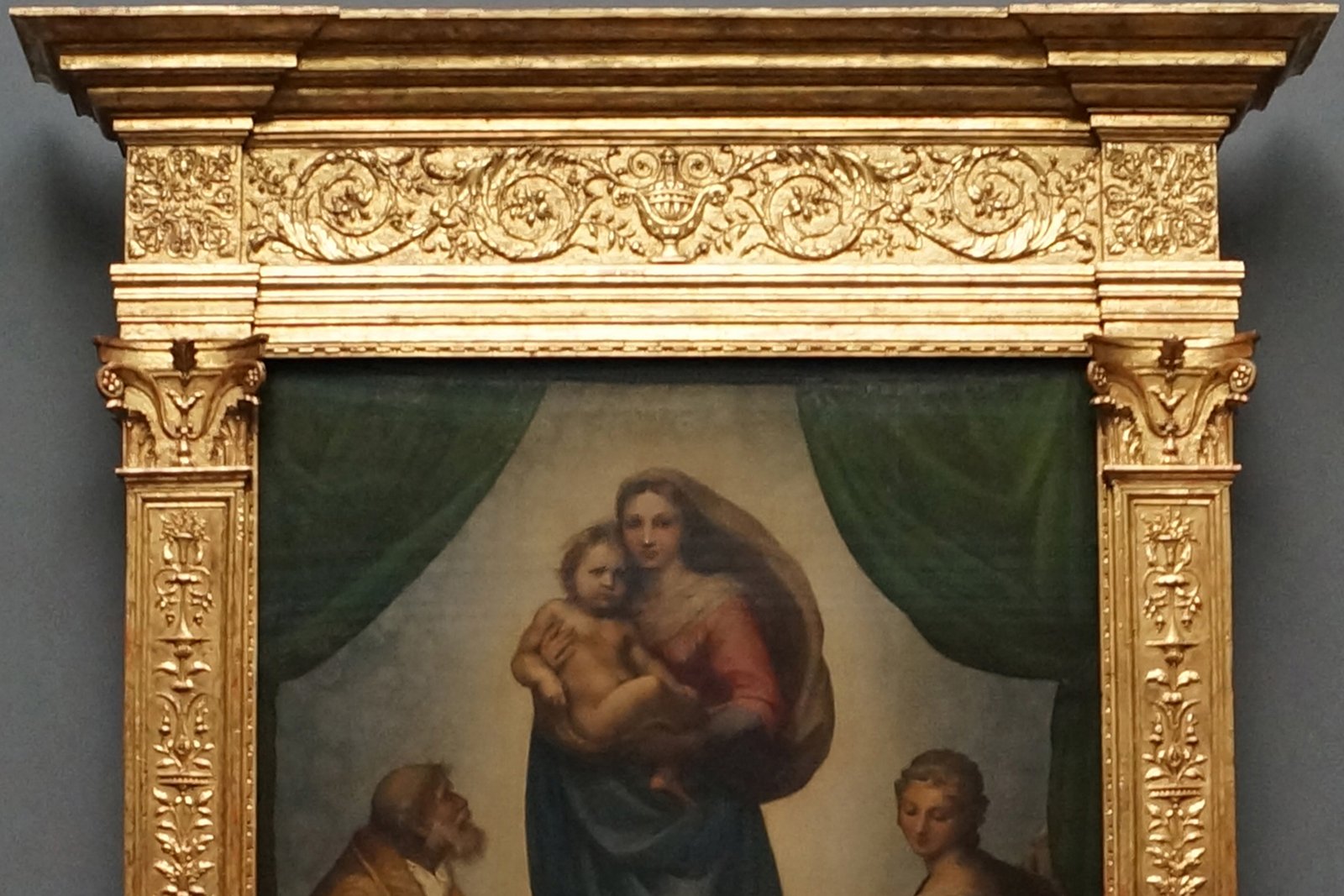 Raphael's Sistine Madonna showing the Virgin Mary holding the Christ Child, flanked by Saint Sixtus and Saint Barbara, with two winged cherubs at the bottom.