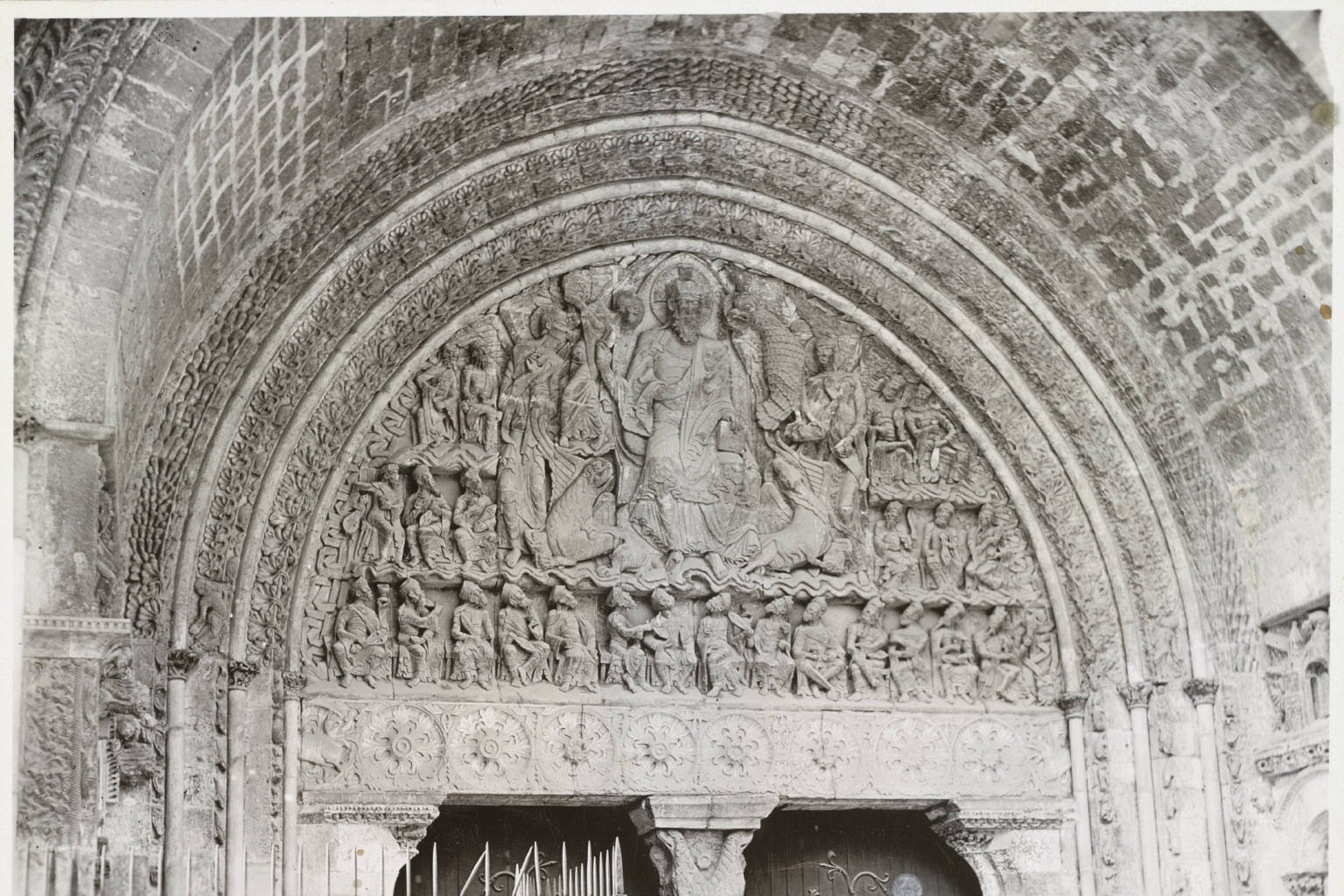 The carved stone tympanum above the south portal of Moissac Abbey, showing Christ in Majesty surrounded by the symbols of the four Evangelists and rows of elders.