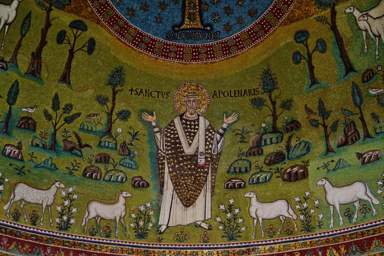 The 6th-century apse mosaic of Saint Apollinaris in the Basilica of Sant'Apollinare in Classe, Ravenna, showing the bishop-saint standing in a green pastoral landscape with twelve sheep.