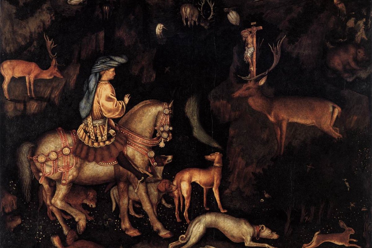 A Renaissance painting of a richly dressed hunter on horseback surrounded by hounds, encountering a stag in a dark forest with a glowing crucifix fixed between its antlers.