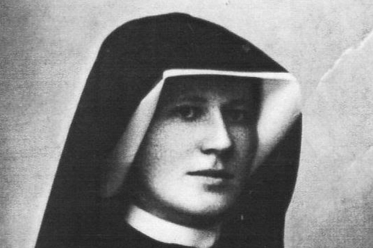 Un ritratto fotografico in bianco e nero di una giovane suora con un abito scuro e una cuffia bianca, lo sguardo rivolto direttamente verso l'obiettivo.