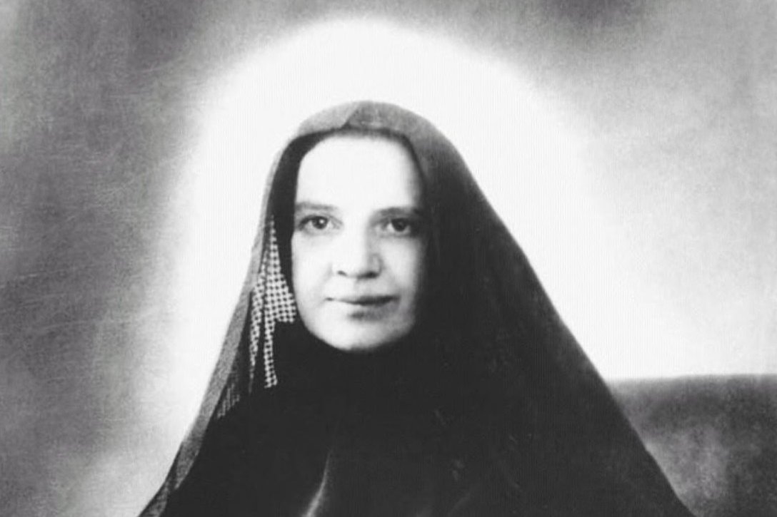 A black-and-white portrait photograph of Frances Xavier Cabrini seated, wearing her religious habit and a cross necklace.