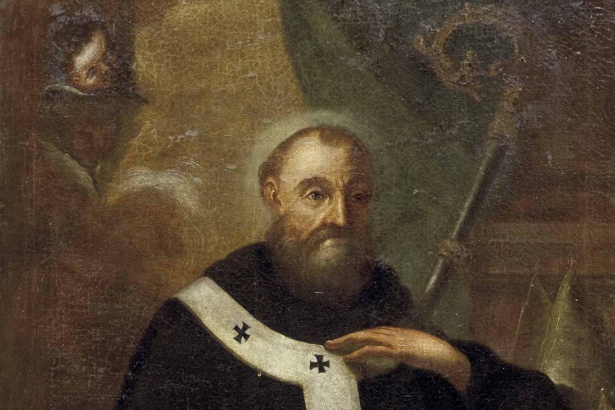 A dark 17th-century oil painting of a bearded bishop saint in black monastic robes and a white pallium marked with crosses, holding an open book inscribed with a Latin motto on charity.