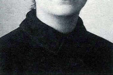 Una fotografía de época en blanco y negro de una joven italiana de cabello oscuro, con un vestido sencillo de cuello alto, mirando suavemente hacia un lado.