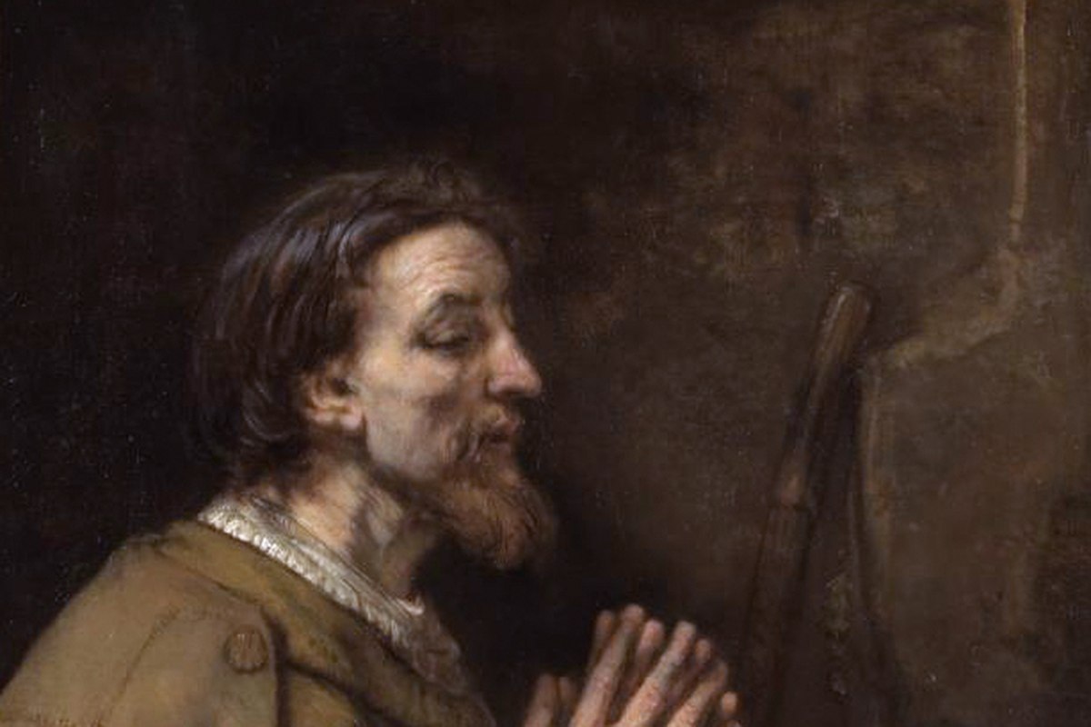 Un dipinto ravvicinato di un uomo anziano e barbuto di profilo, mani giunte in preghiera, con un bastone da pellegrino visibile accanto a lui.