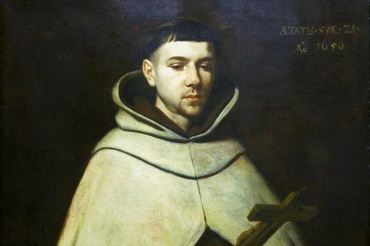 Retrato de tres cuartos de un joven fraile carmelita con capa y capucha blancas, sosteniendo un pequeño crucifijo de madera.