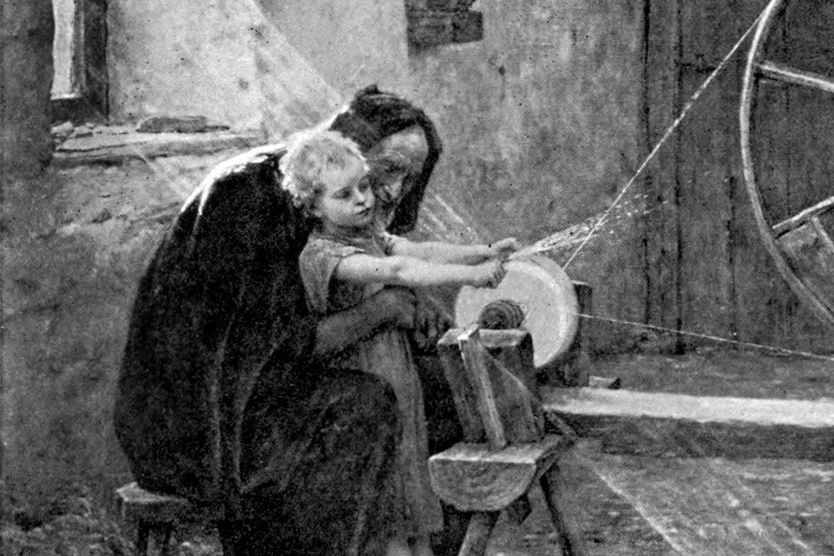 A monochrome painting of Saint Joseph, an elderly carpenter, guiding a young Jesus by the hands as the child works a hand-cranked grindstone in a village workshop.