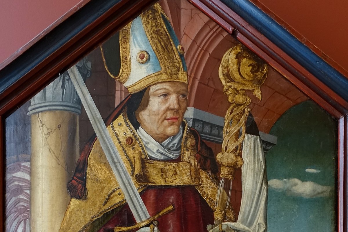 A c. 1520 painted altarpiece panel showing a bishop saint in gold pontifical vestments and a mitre, holding a sword in one hand and a crozier in the other, from the Mainfränkisches Museum in Würzburg.