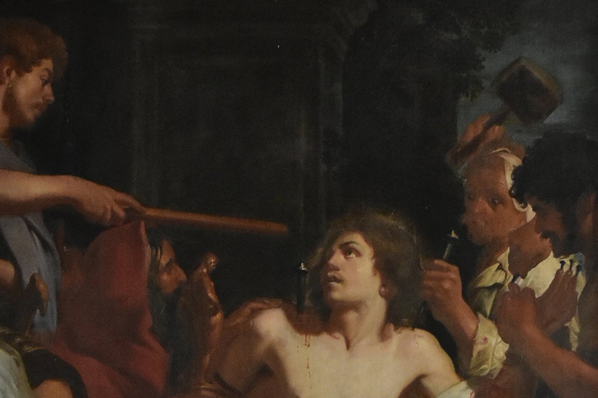 A Baroque oil painting of the young martyr Saint Quentin, bare-chested and bleeding, gazing upward as Roman soldiers torture him with a spike and mallet.