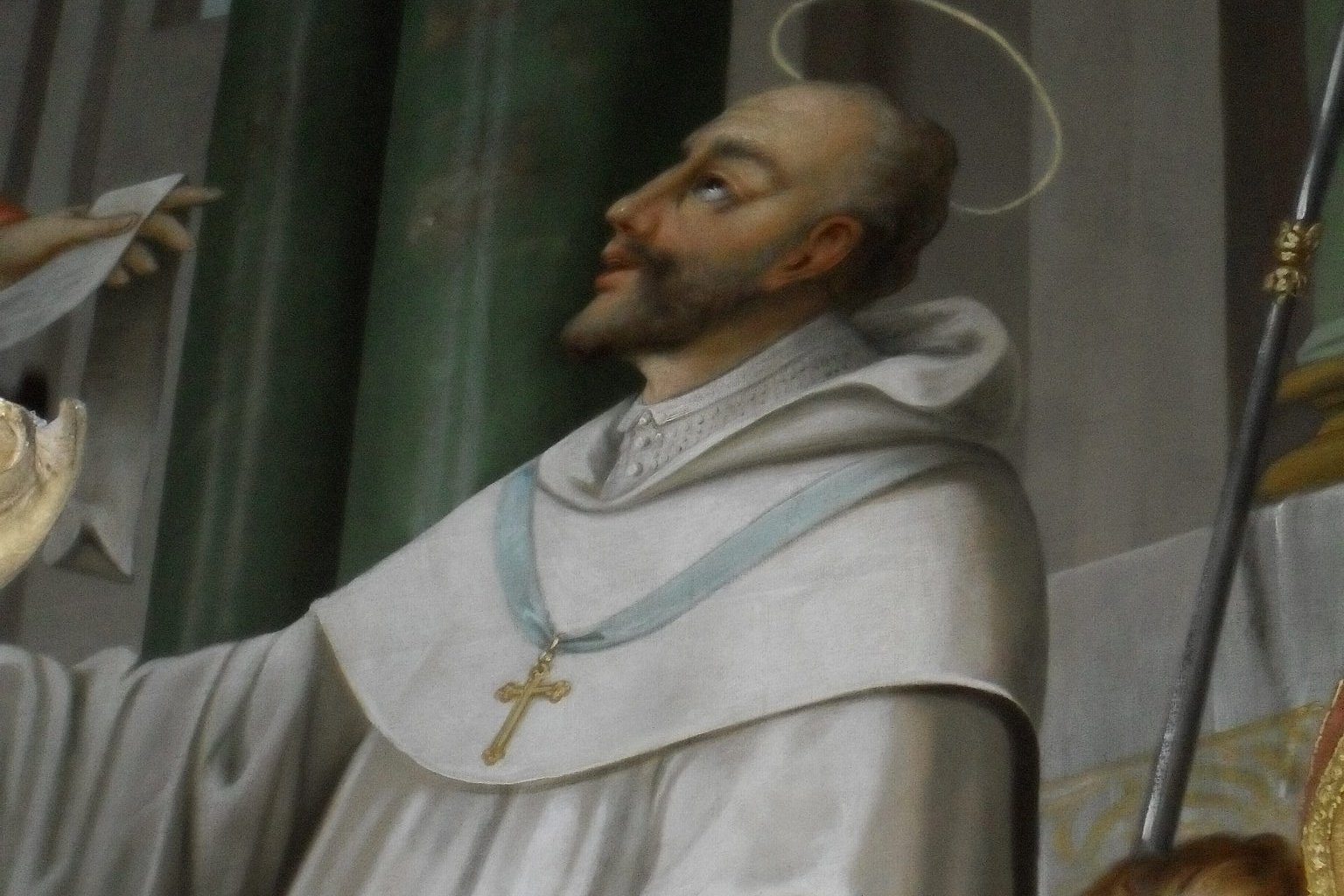 An icon-style painted portrait of a tonsured medieval monk in white Cistercian habit, holding a book, with a halo.
