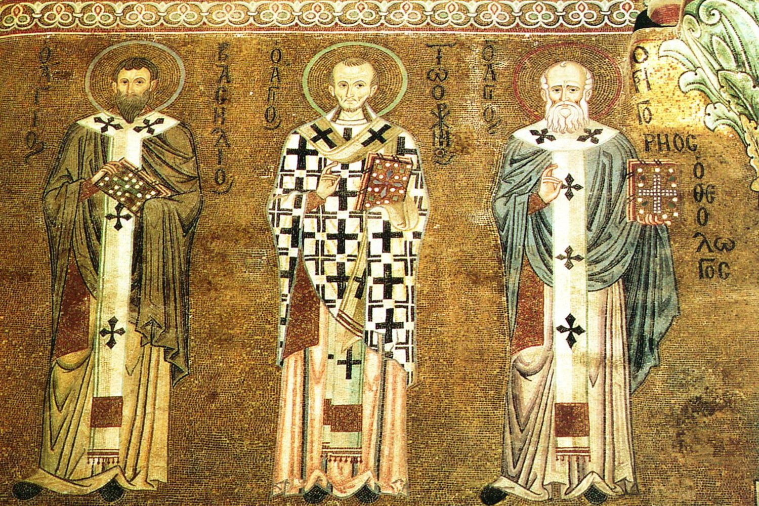 A Byzantine mosaic of three bearded bishop-saints in white and gold liturgical vestments, including Saint Basil the Great and Saint Gregory Nazianzen, each holding a jeweled Gospel book.