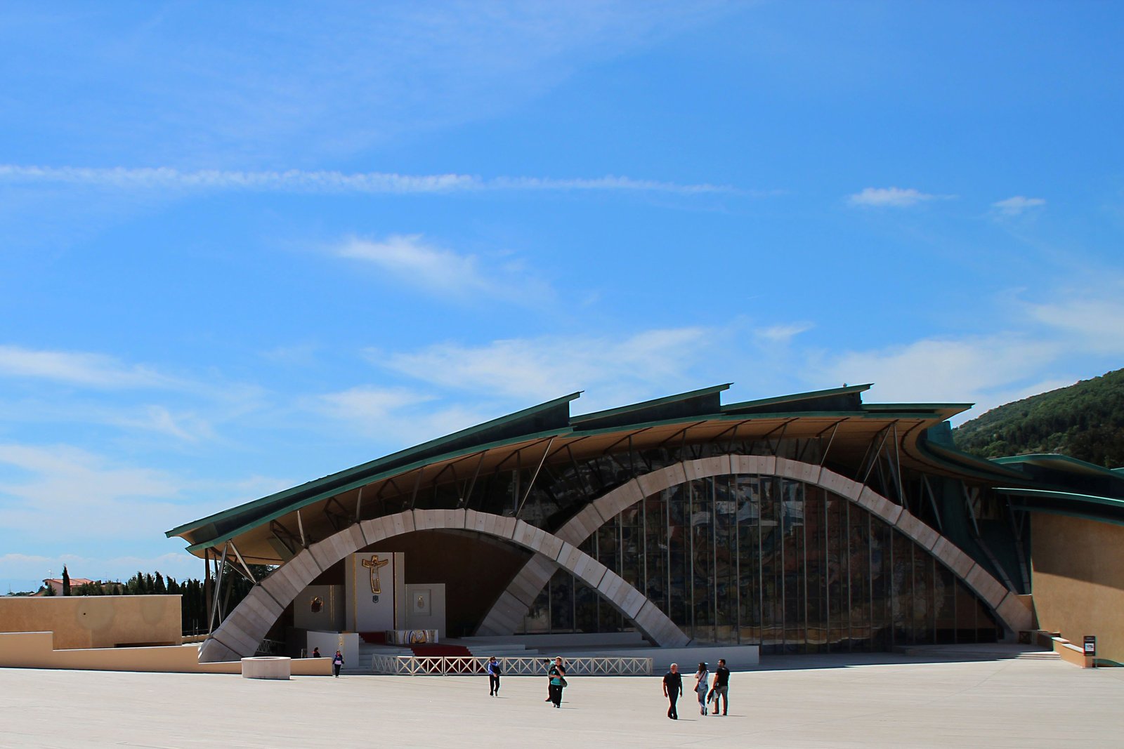 The modern shell-shaped shrine church of Saint Pio of Pietrelcina in San Giovanni Rotondo, Italy, with its sweeping arched roof and glass walls.