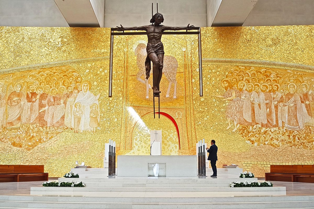 The golden mosaic sanctuary and crucifix inside the Basilica of the Holy Trinity at Fatima