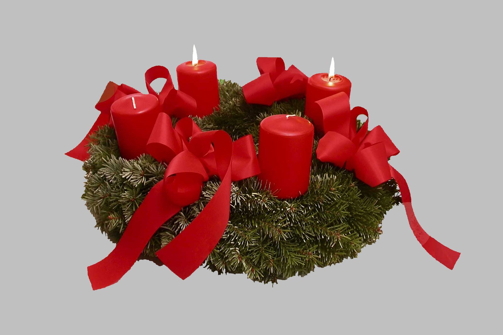 Una tradizionale corona d'Avvento fatta di rami sempreverdi con quattro candele, tre viola e una rosa, disposte in cerchio.