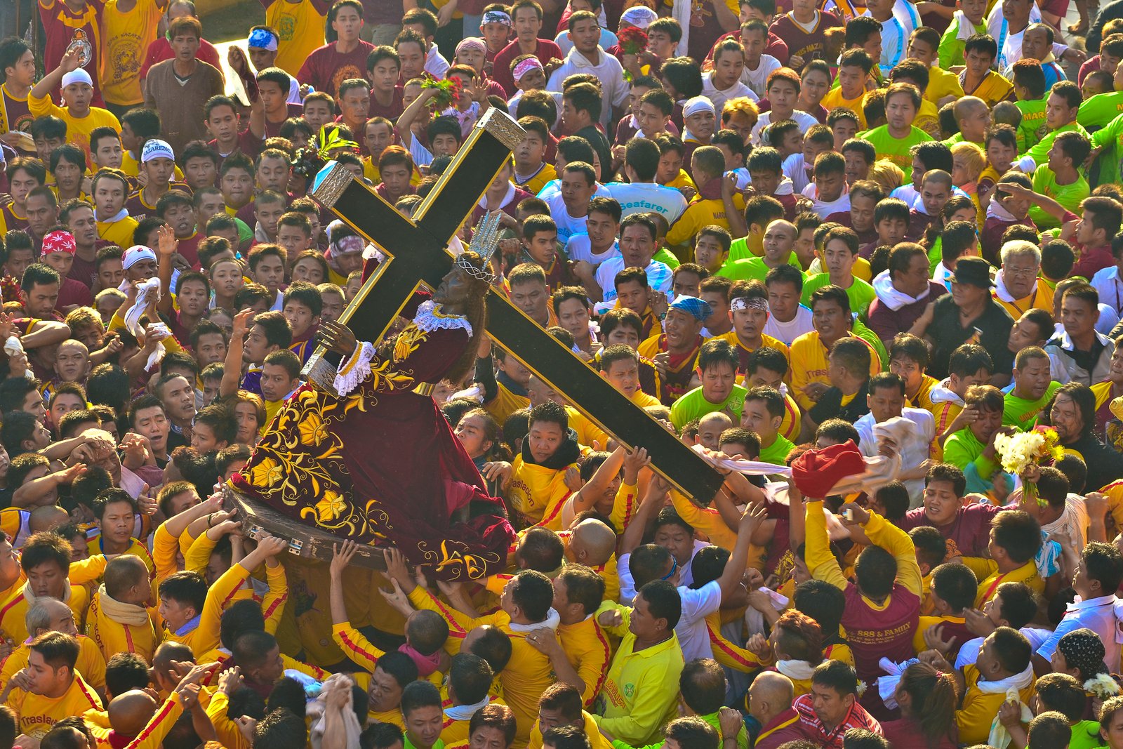 Crowds of barefoot devotees surrounding the carriage of the Black Nazarene during its annual procession through the streets of Quiapo, Manila