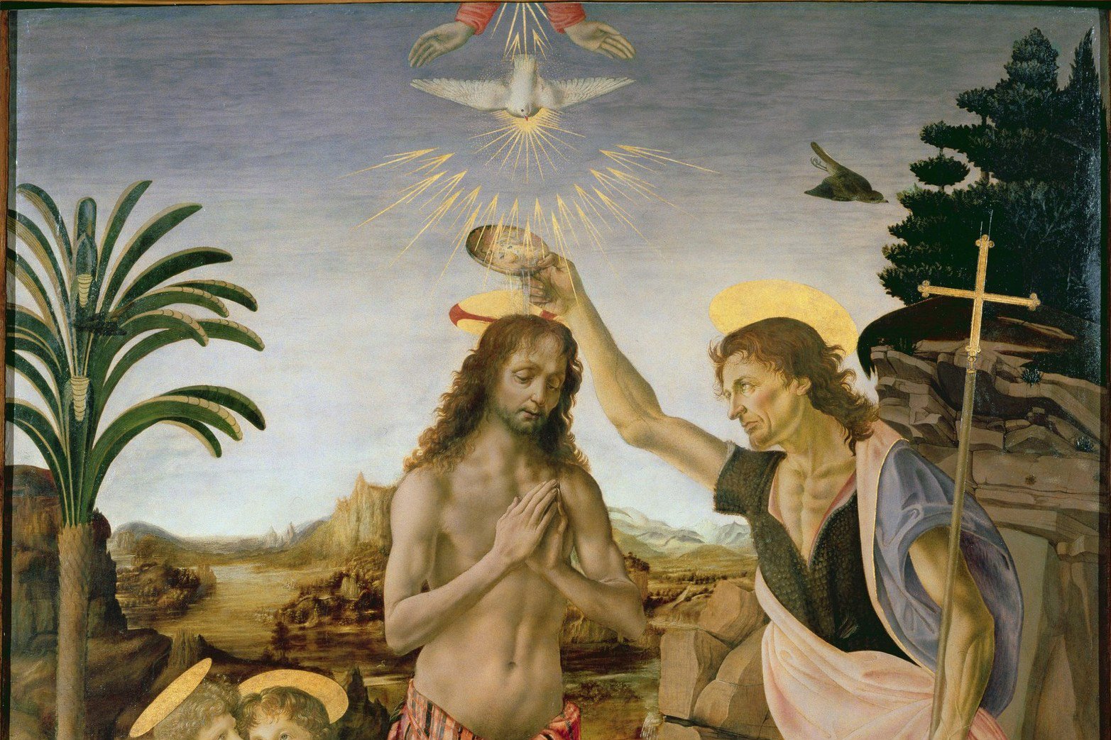 A Renaissance painting of the baptism of Christ, with a white dove surrounded by golden rays descending directly above his head.