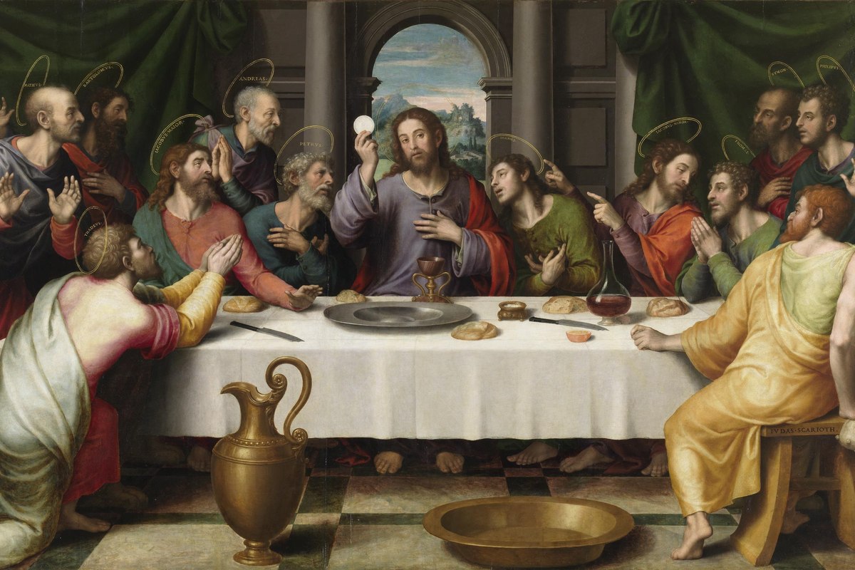 A devotional depiction of Jesus seated at a table with his apostles, breaking bread and raising a cup.