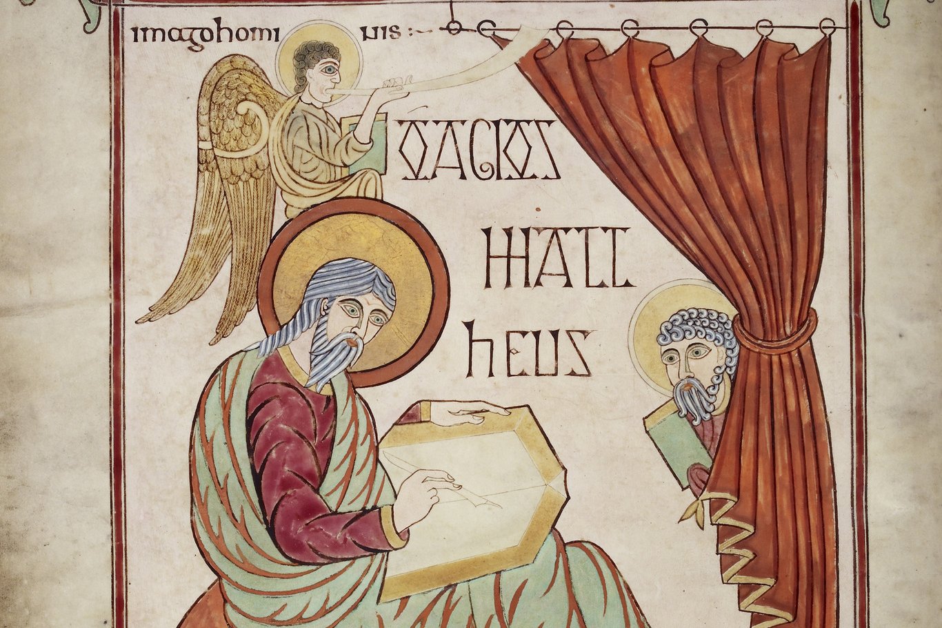 Illuminated portrait page from the Lindisfarne Gospels depicting Saint Matthew writing, framed by an elaborate decorated border of interlace patterns.