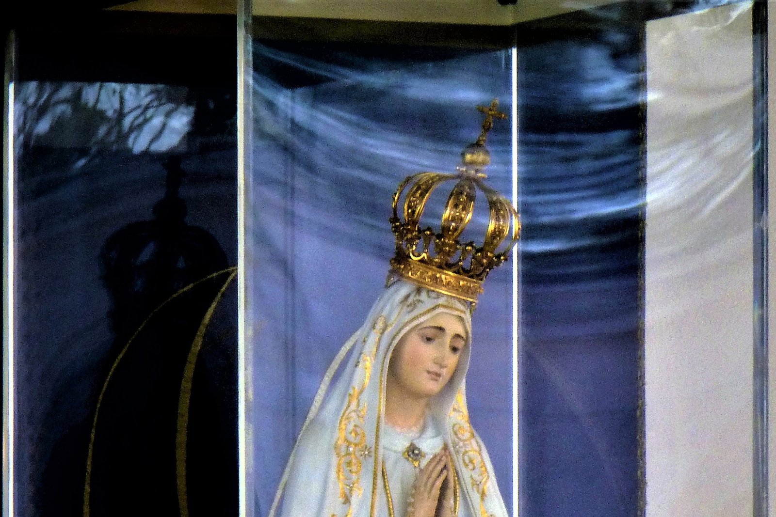 Close-up of the original 1920 statue of Our Lady of Fatima, carved in cedar wood, wearing its jeweled gold crown inside the Chapel of the Apparitions