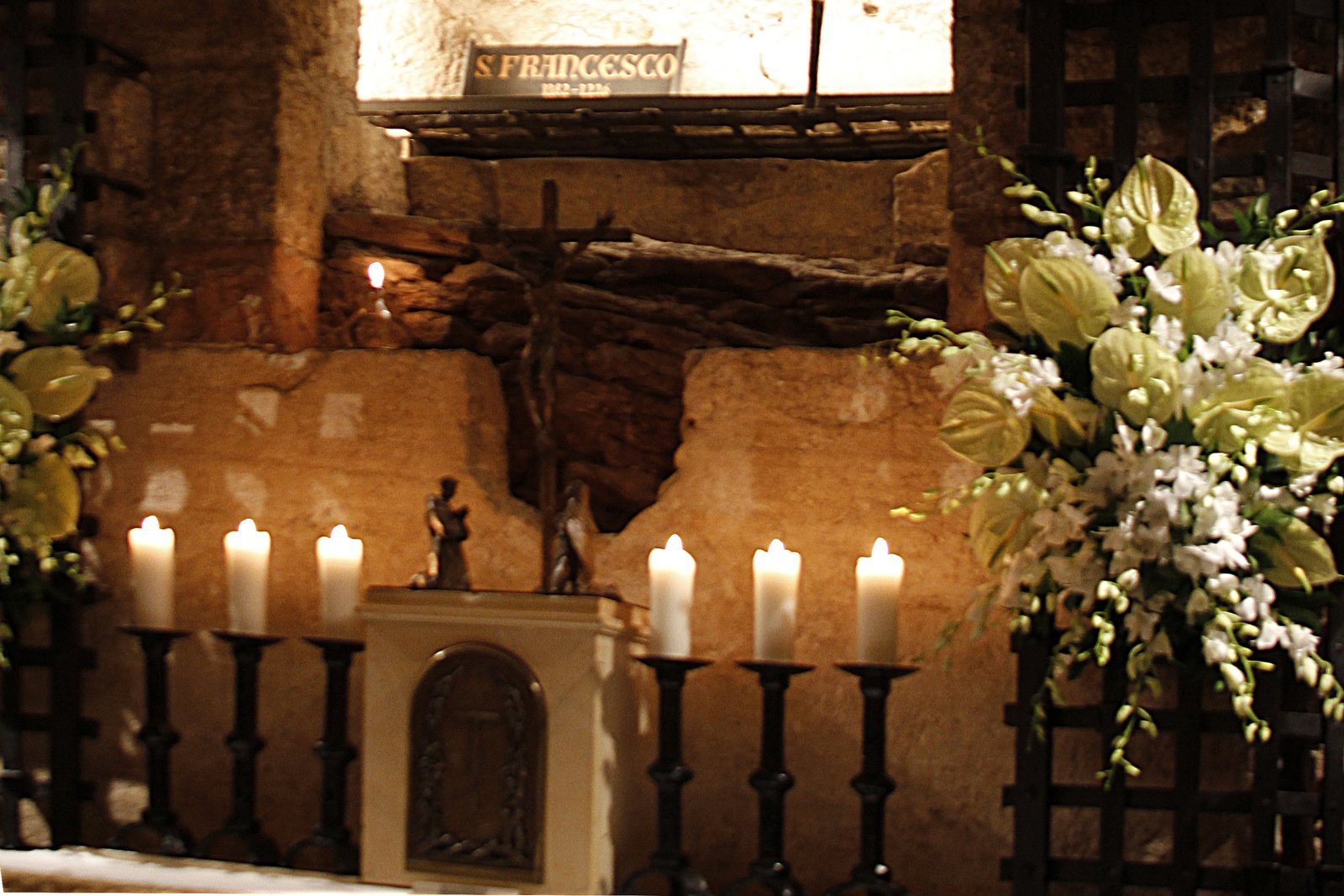 The stone sarcophagus of Saint Francis of Assisi in the crypt of the Basilica of San Francesco, Assisi, surrounded by an iron grille