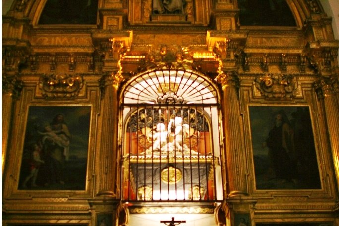 The gilded reliquary shrine at the Carmelite convent in Alba de Tormes, Spain, where Saint Teresa of Avila's relics are enshrined behind an iron grille.