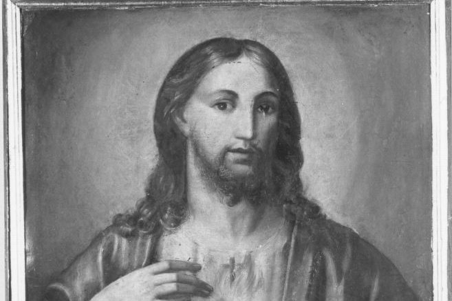 A half-length devotional painting of Jesus Christ gesturing toward a glowing heart wrapped in a crown of thorns visible on his chest.