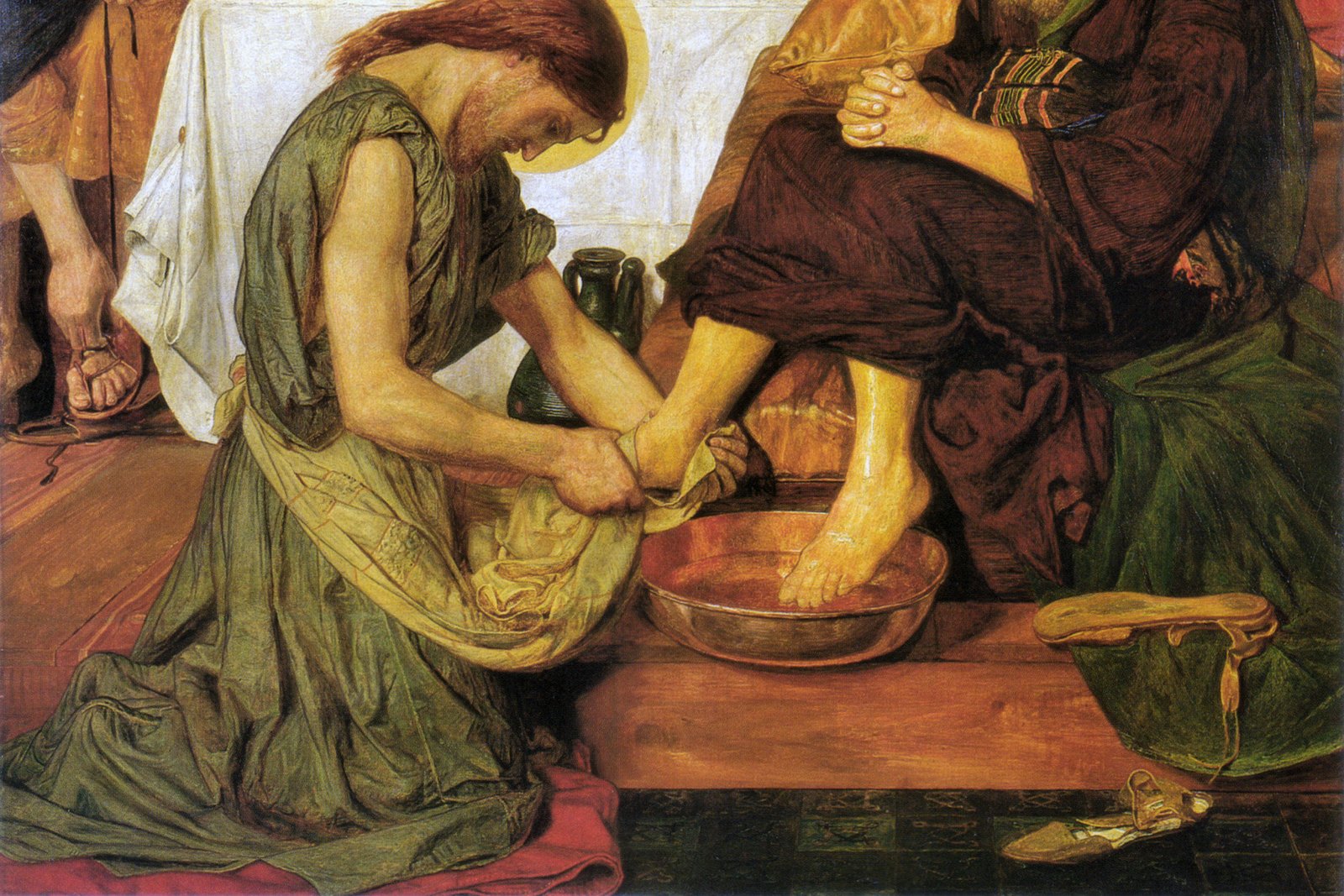 A painting of Jesus kneeling to wash the feet of one of his apostles at a gathering of the twelve disciples.