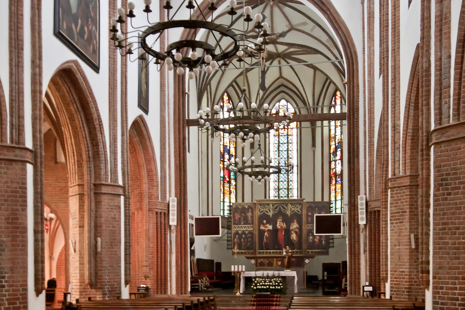 The richly decorated interior of a Catholic cathedral, showing statues, altar, and architectural detail.